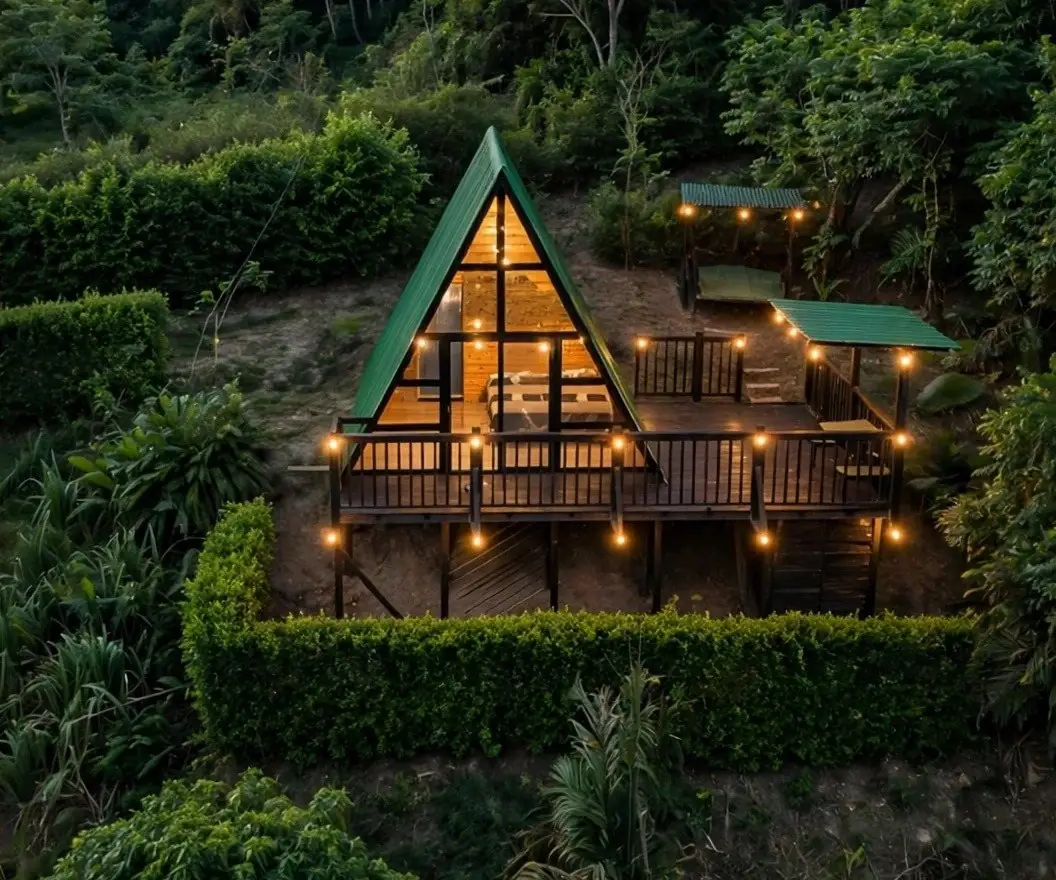 An A-frame cabin lit at night in the forest