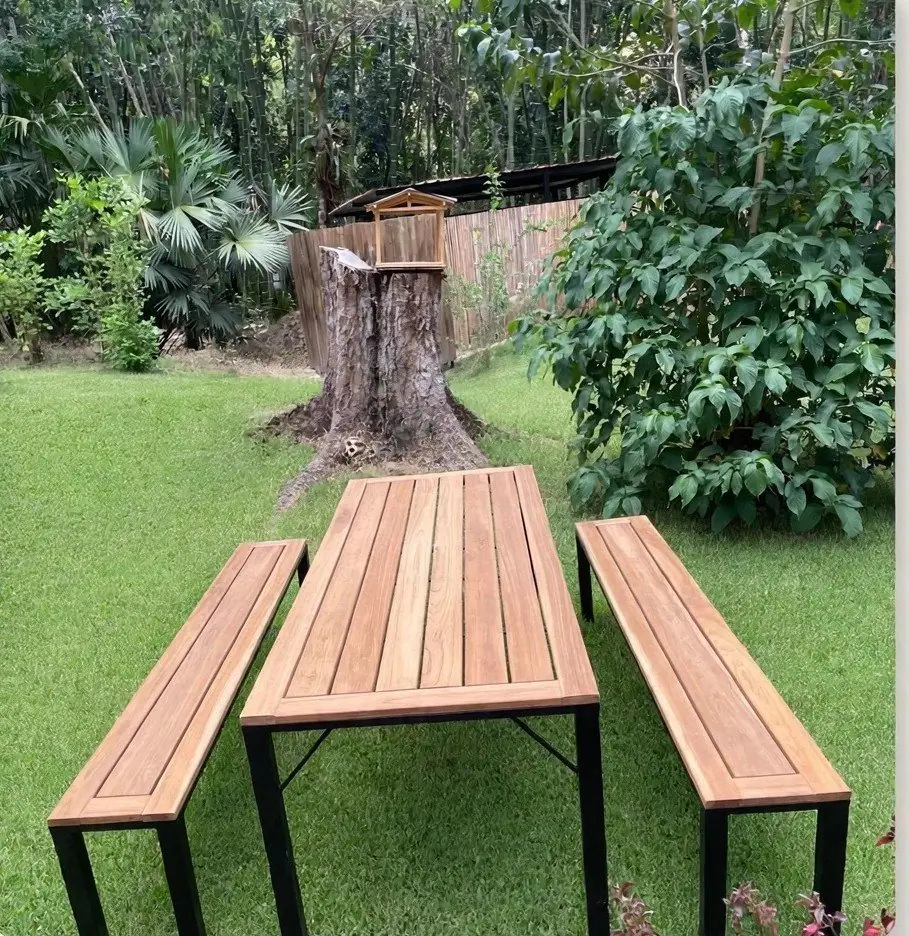 Teak picnic table and benches on a green lawn